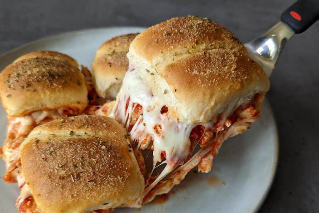 Cheesy chicken parm sliders being served from a plate