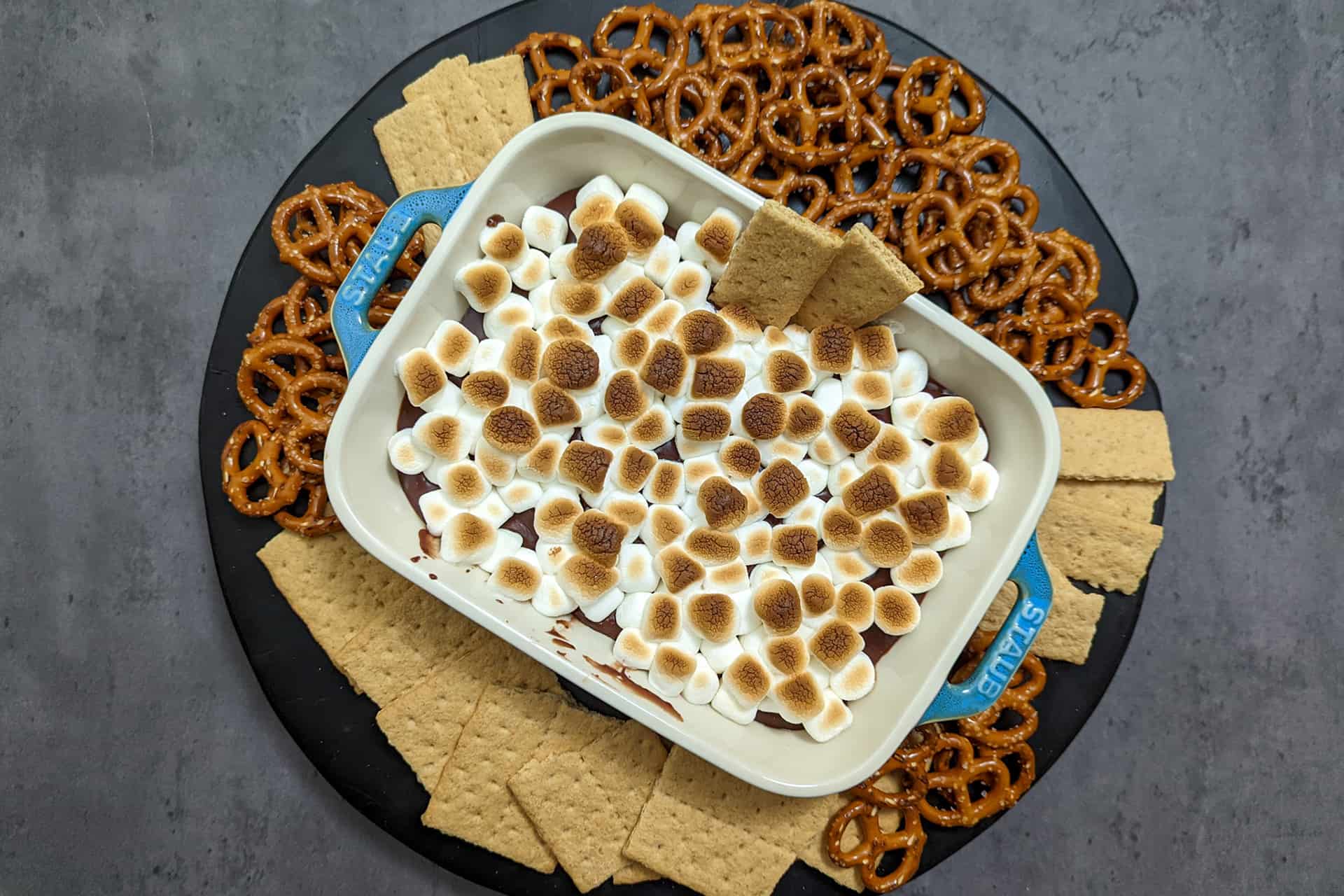 A s'mores dip platter with graham crackers and pretzels