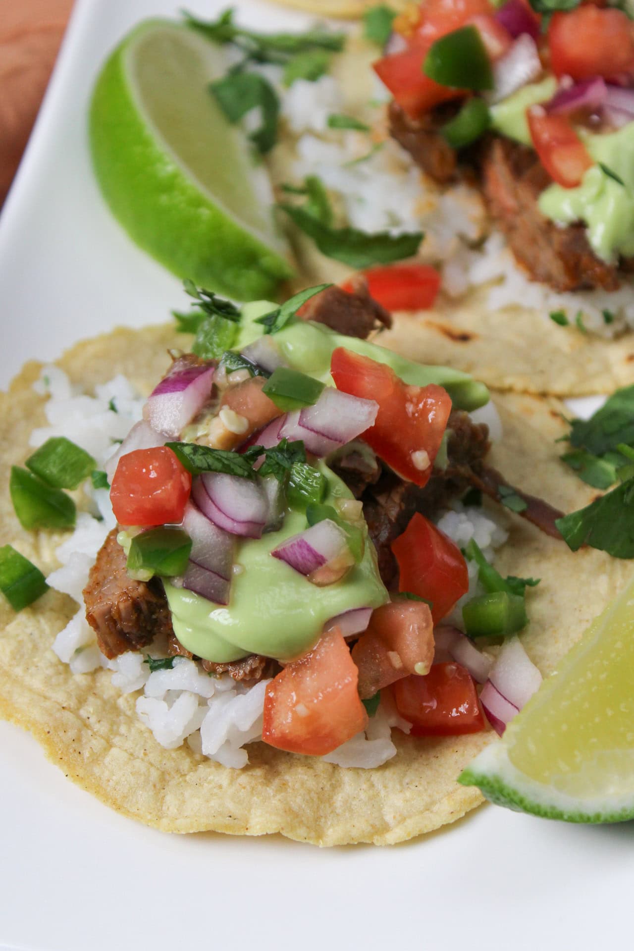 A carne asada taco with pico de gallo and avocado crema.