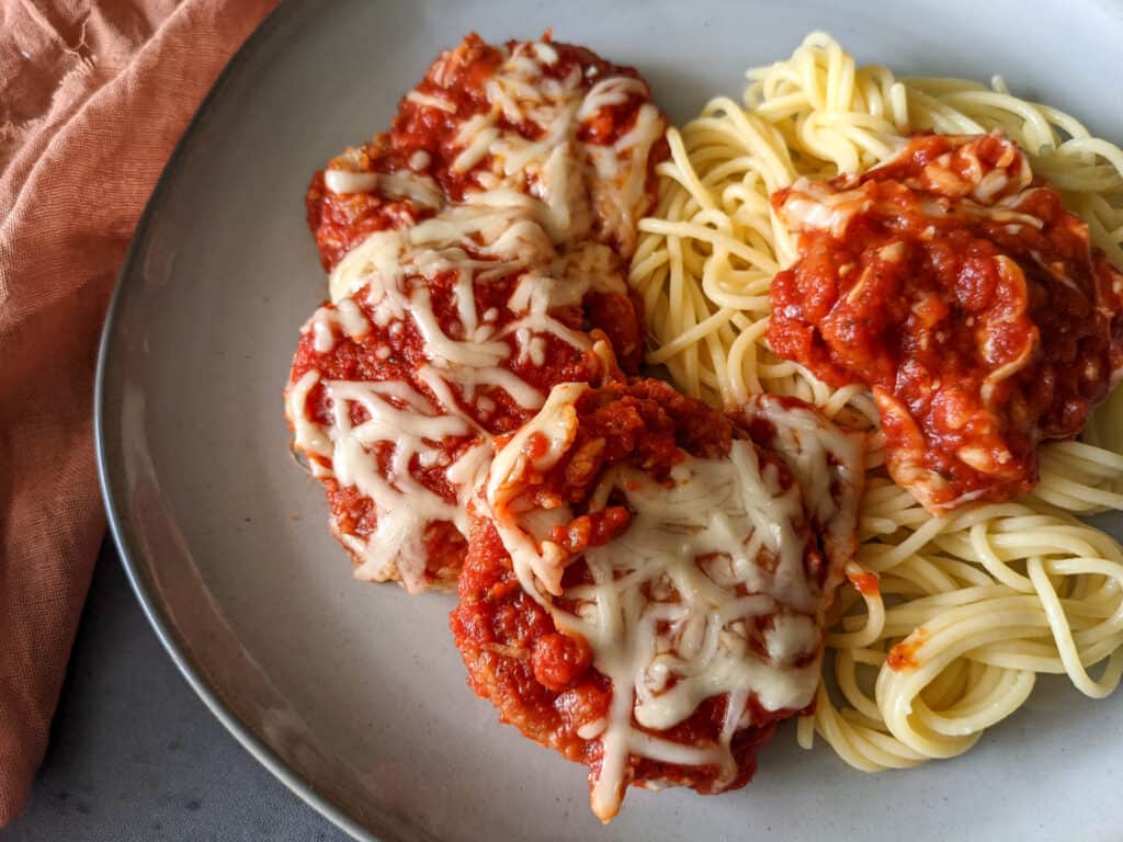 Eggplant parmesan on a plate with spaghetti