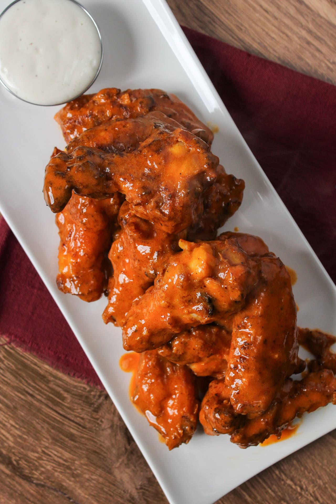 A plate of crispy air fryer buffalo chicken wings that are drenched in sauce and served with ranch.