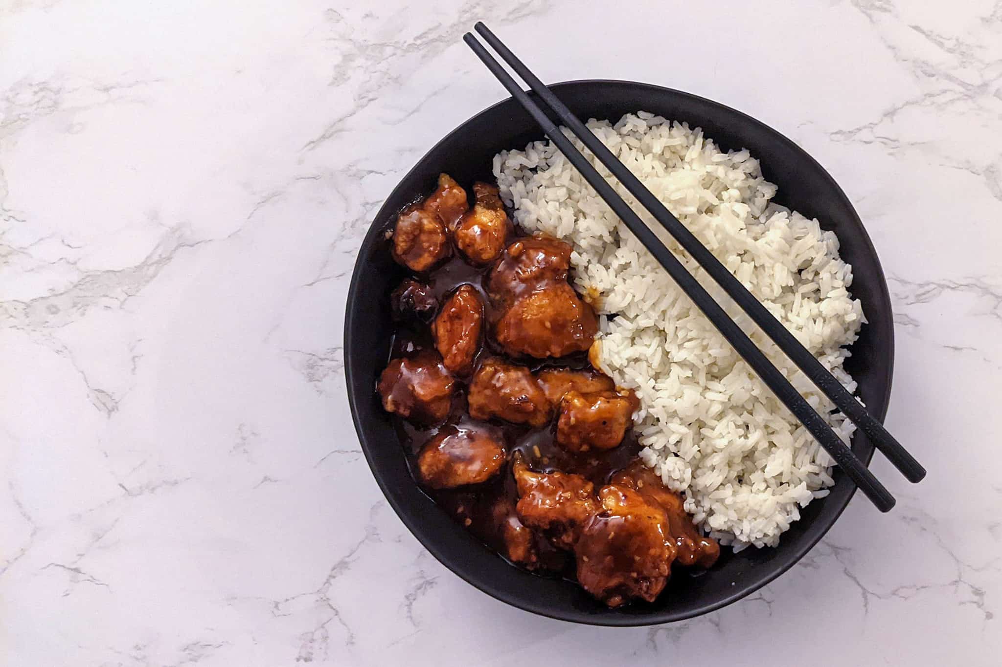 A bowl of General Tso's chicken served with white rice