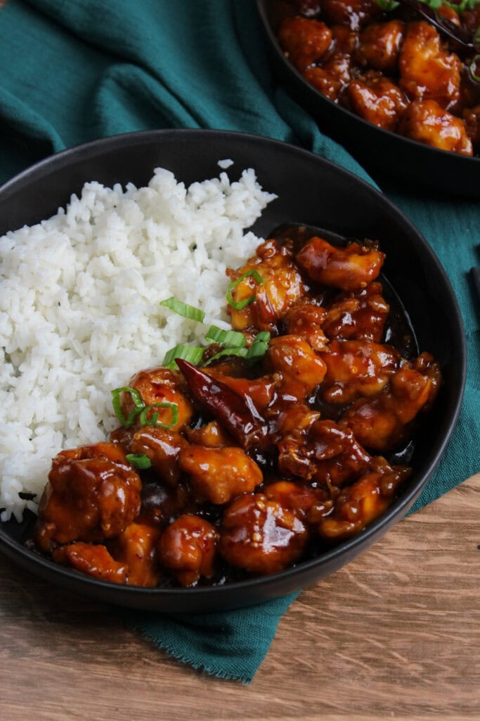 A bowl of general tso's chicken with rice.