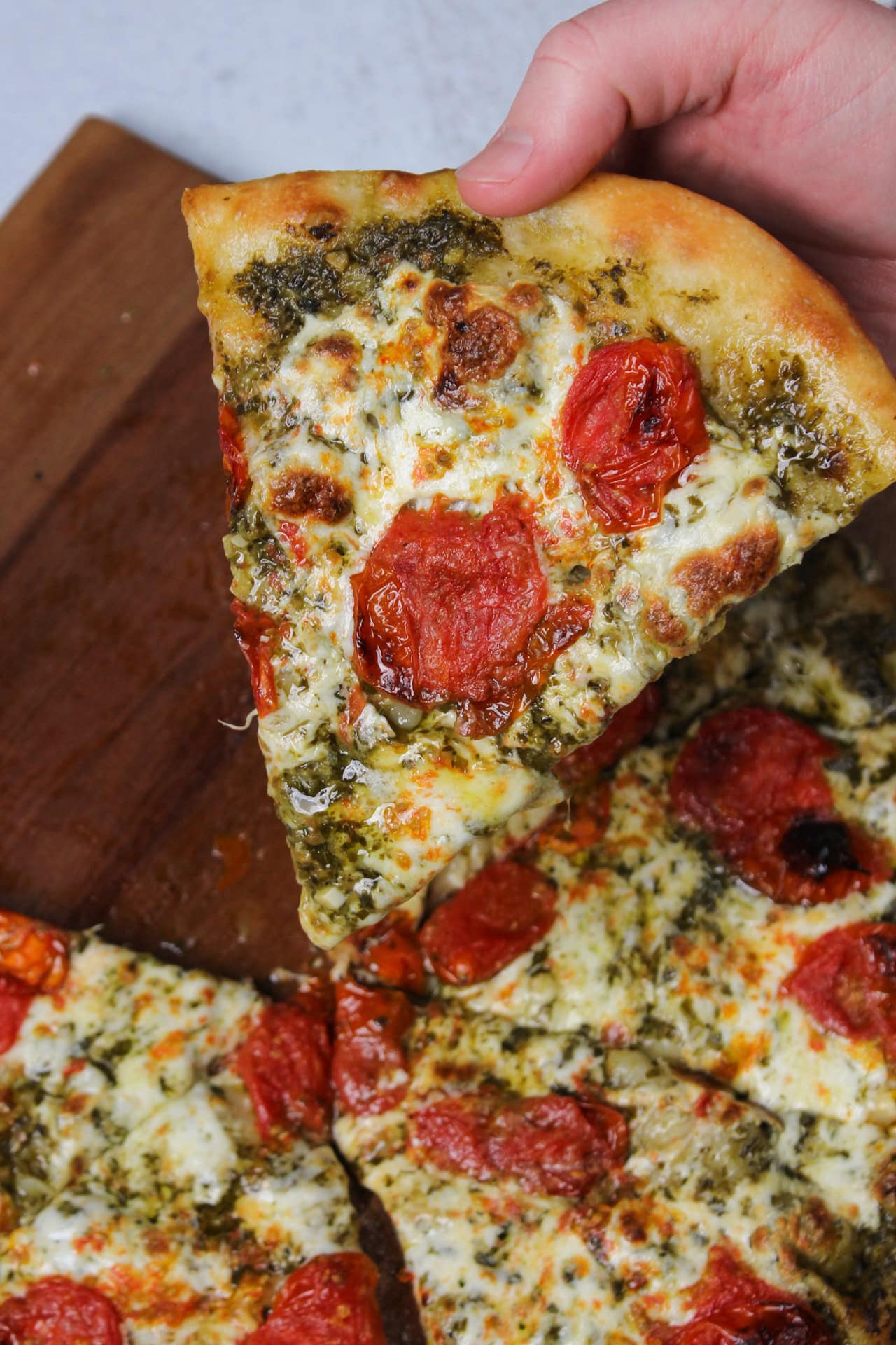 Pesto pizza with roasted tomatoes and mozzarella.
