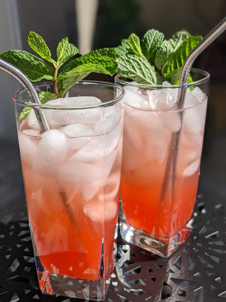 Two strawberry jalapeno mojitos garnished with mint sprigs