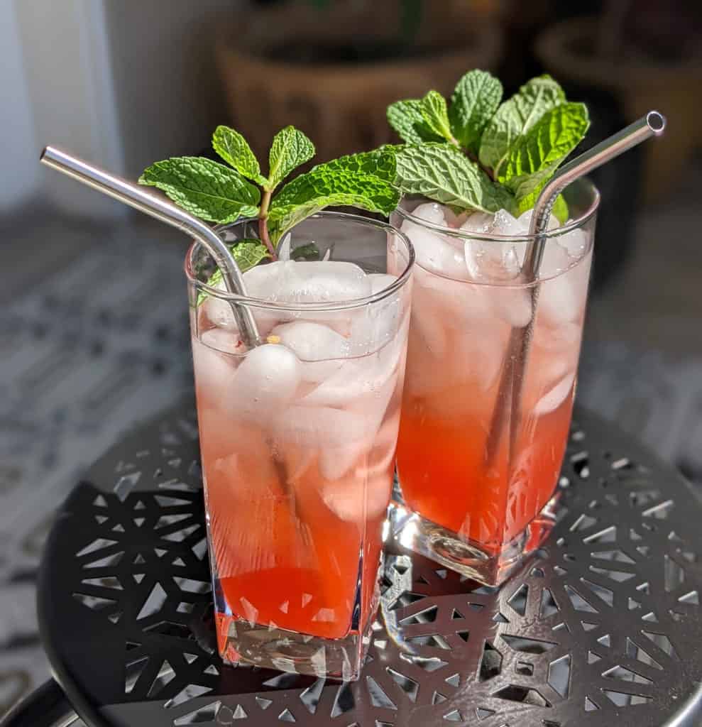 Two strawberry jalapeno mojitos garnished with mint sprigs