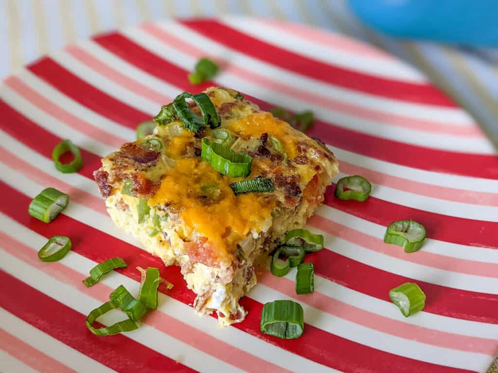 A holiday breakfast casserole with eggs, bacon, and veggies