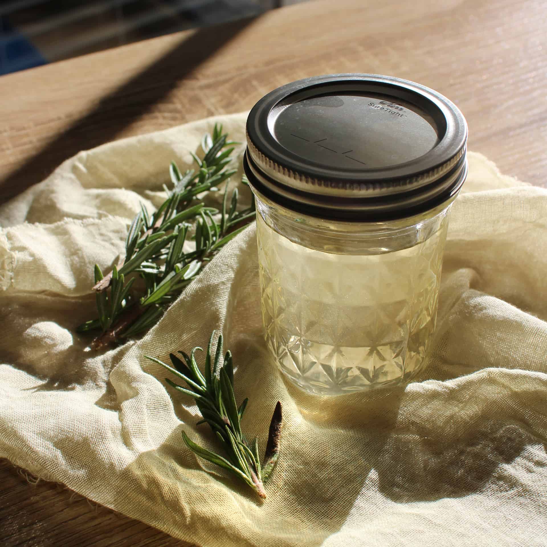 Rosemary simple syrup in a glass jar with an aluminum lid