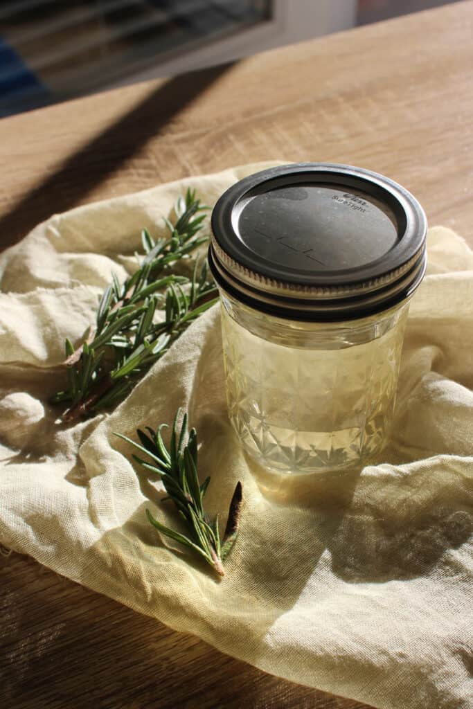 A glass jar of rosemary simple syrup