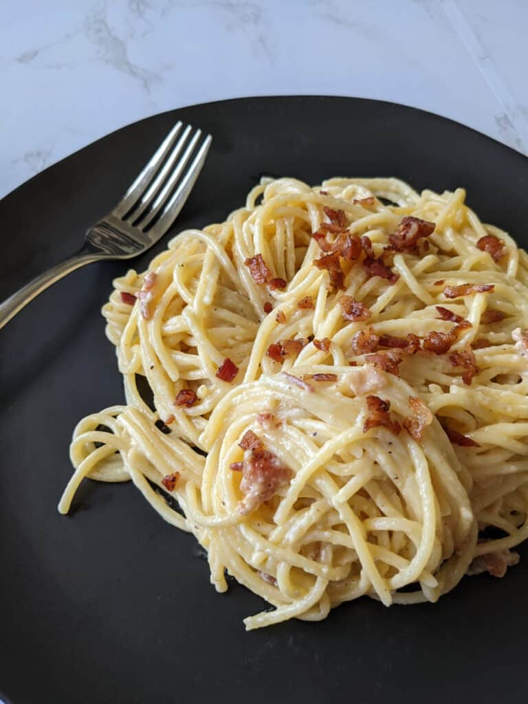 A plate of spaghetti carbonara with bacon