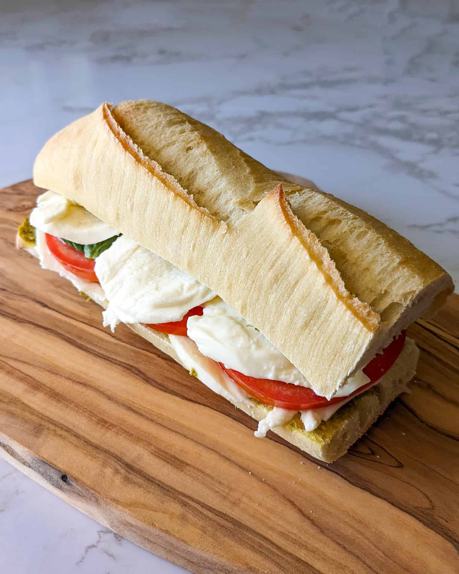 A basil pesto caprese sandwich on baguette