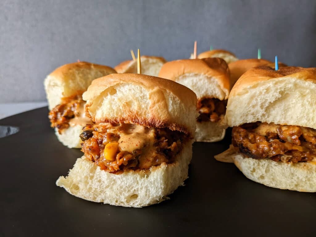 A serving tray of spicy southwest sliders on Hawaiian rolls with chili lime dressing