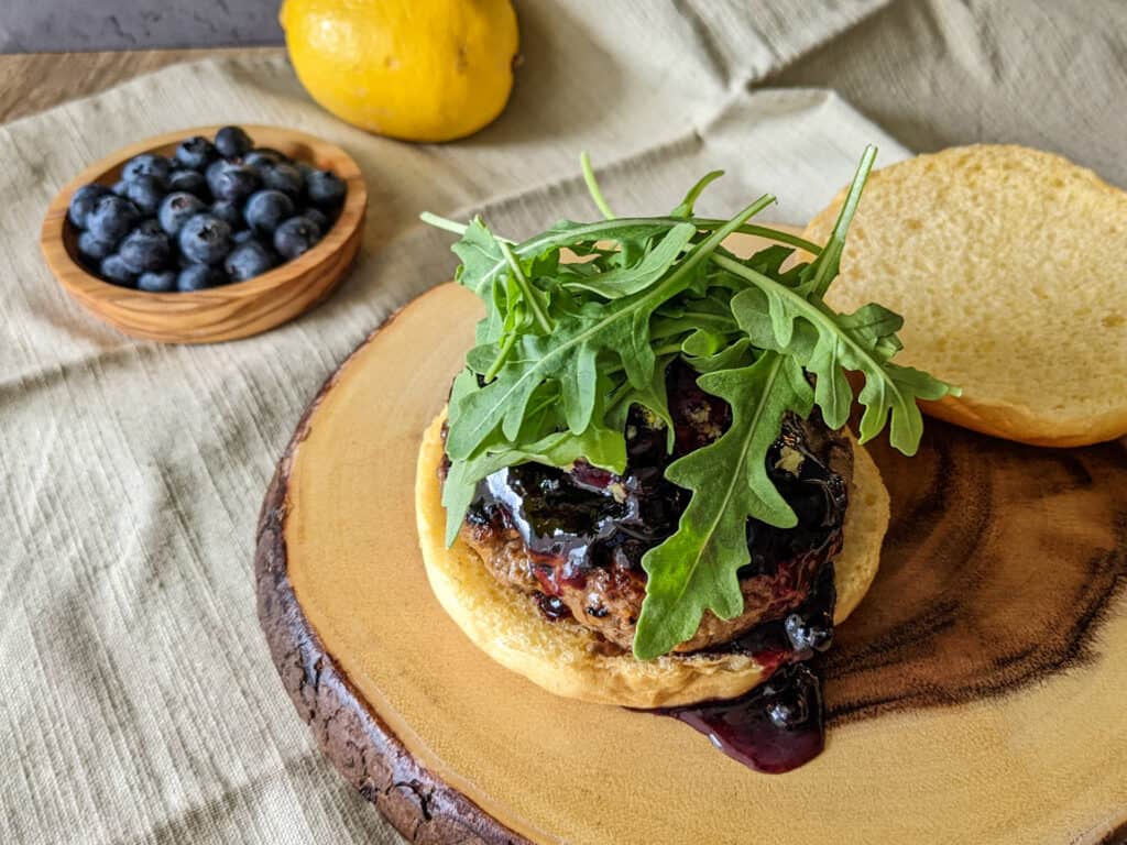 A blueberry lemon goat cheese burger served on a wooden stump