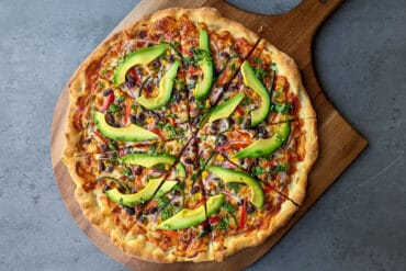 A California style veggie pizza topped with avocado slices