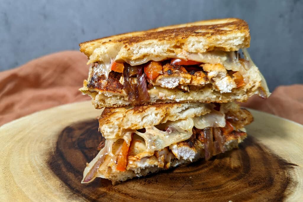A chipotle chicken melt with bell pepper and onion on sourdough
