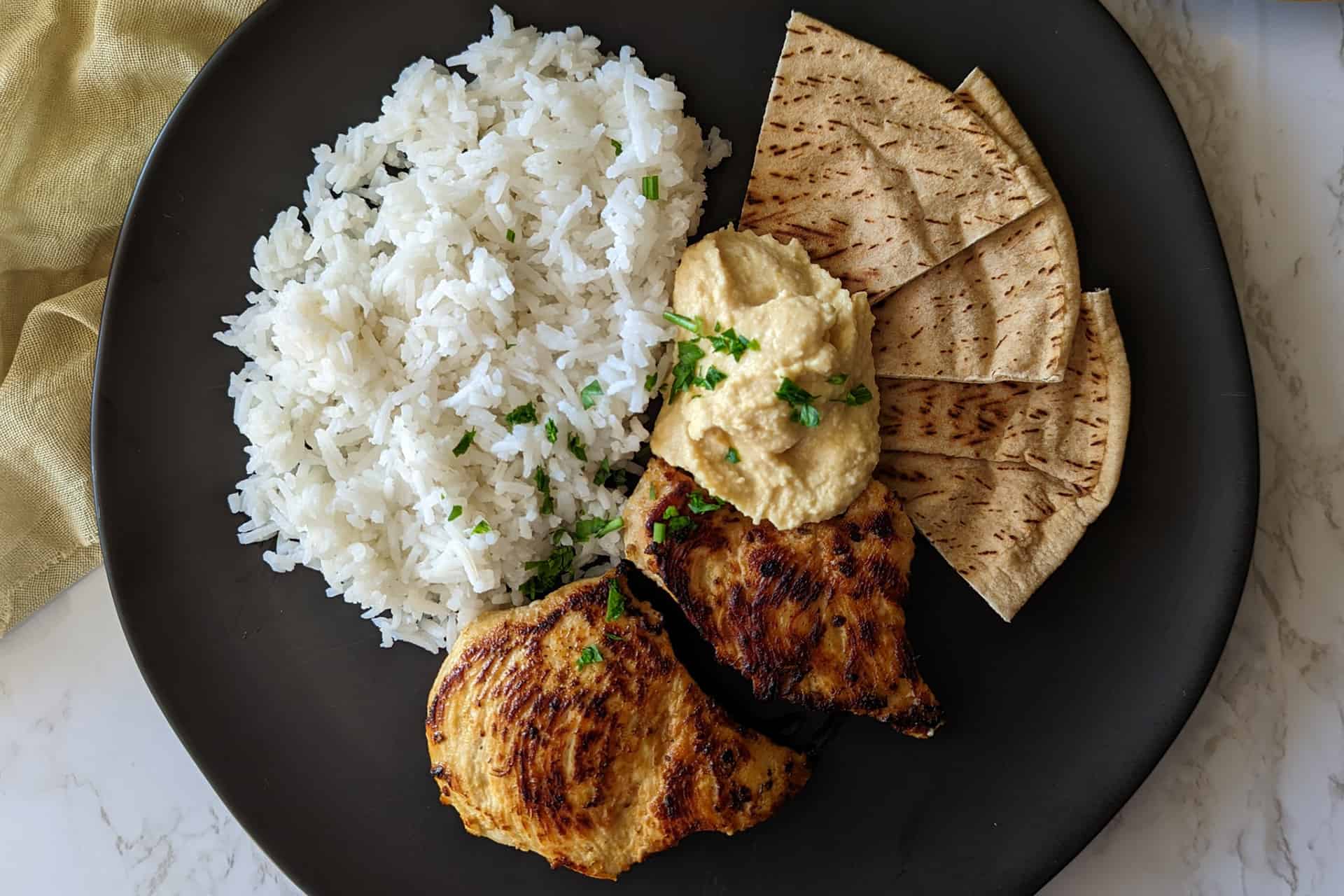 Mediterranean chicken and rice with hummus and pita