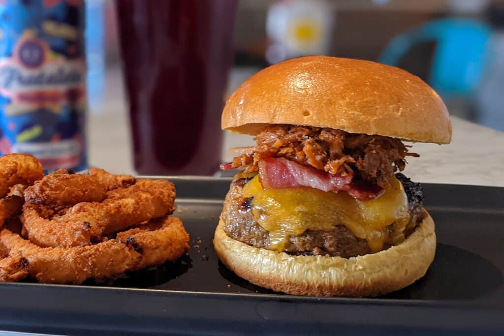 A big pig burger with a beef and pork blend patty, cheddar cheese, bacon, pulled pork, and barbecue sauce