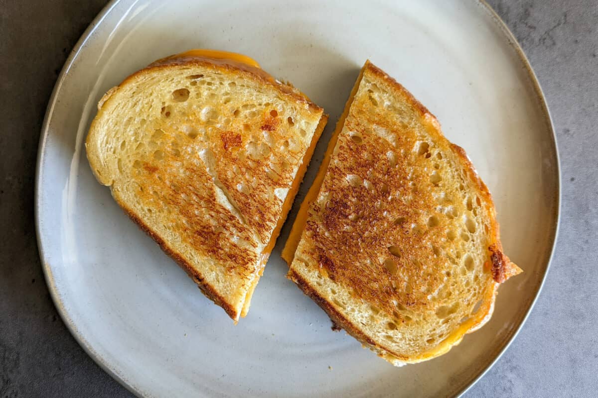 A toasted grilled cheese sandwich cut in half diagonally