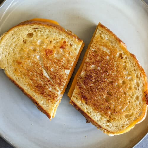 A toasted grilled cheese sandwich cut in half diagonally