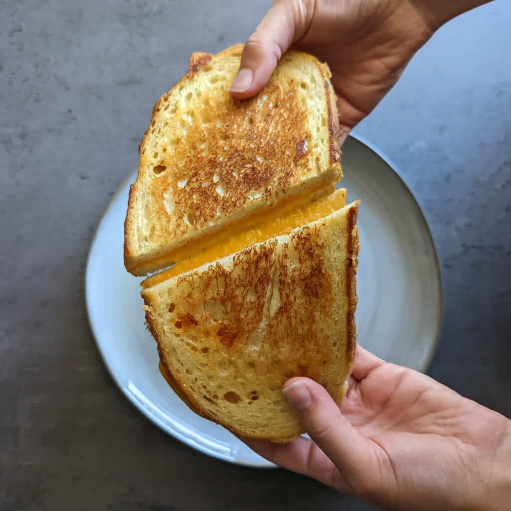 The perfect grilled cheese sandwich being pulled apart into two halves