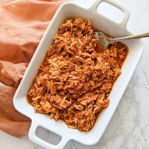 A dish of slow cooker chicken tinga served with a fork