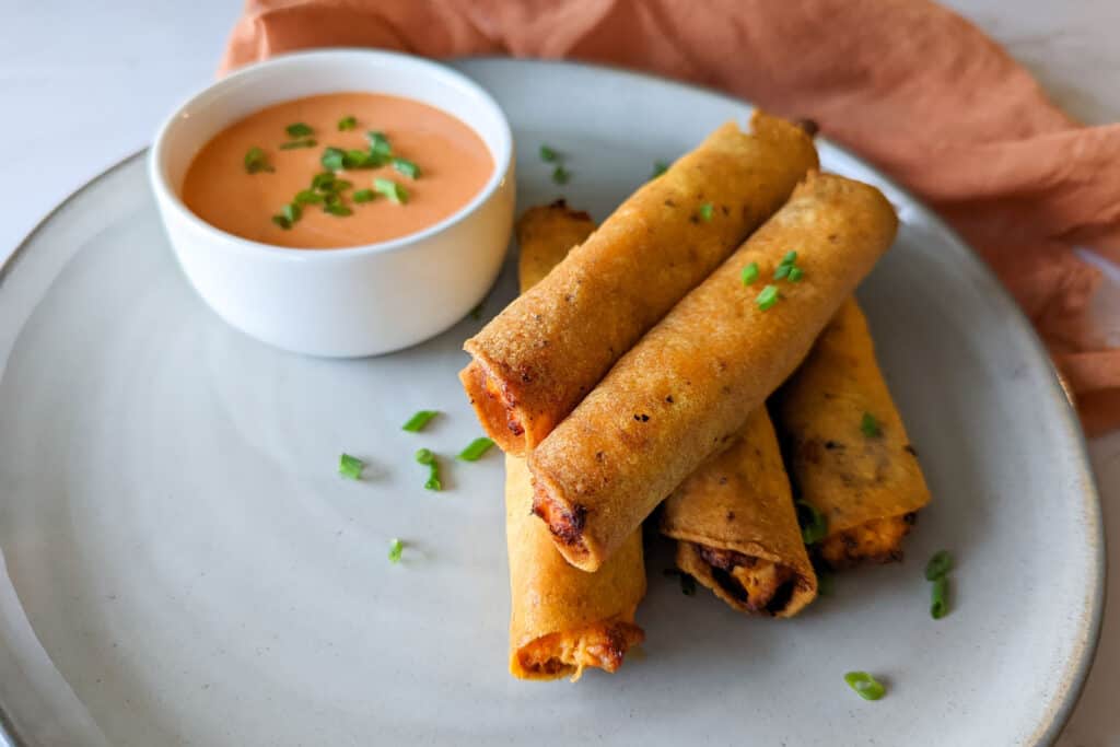 A plate of crispy buffalo chicken taquitos made in the air fryer