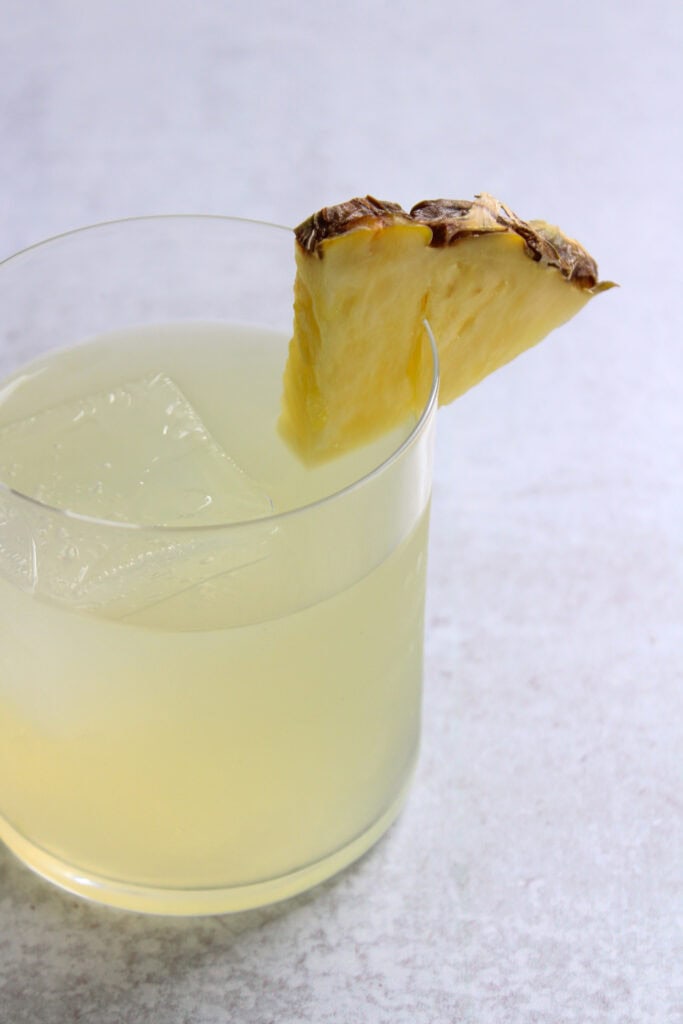 A pineapple wedge garnish on a cocktail.