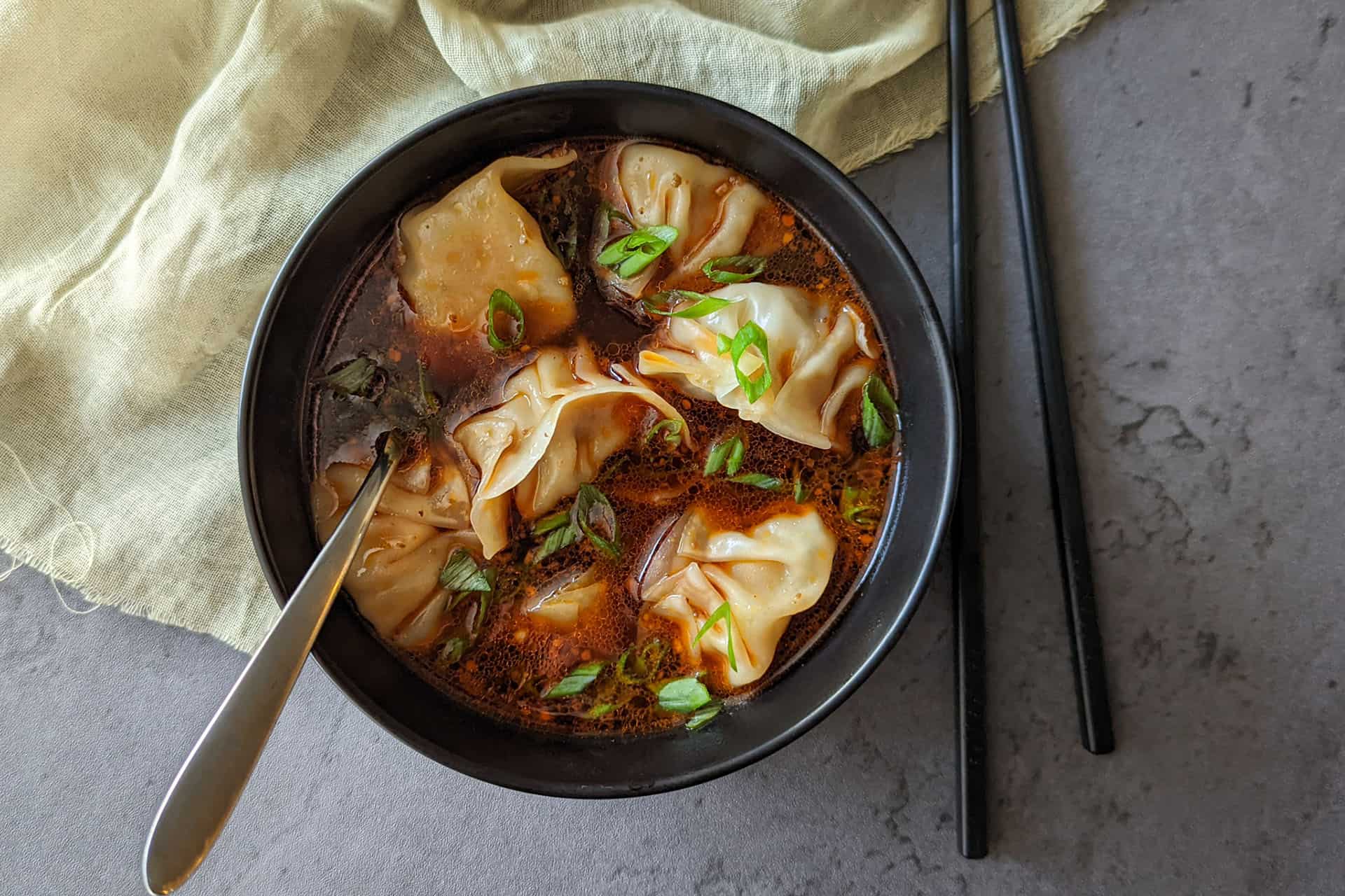 A bowl of spicy szechuan dumpling soup