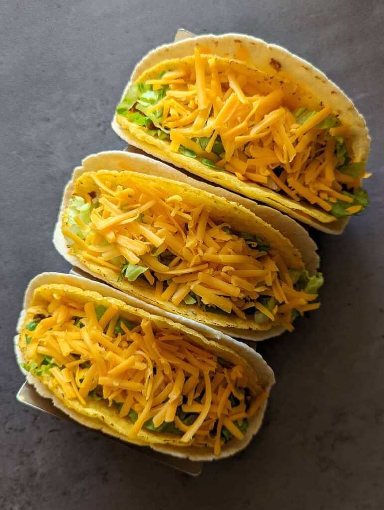 Three cheesy gordita crunch tacos with ground beef, spicy ranch, and lettuce
