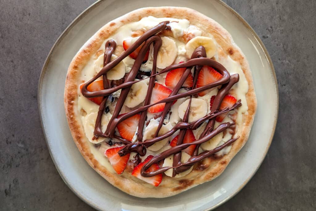 A simple dessert pizza with fruit and nutella