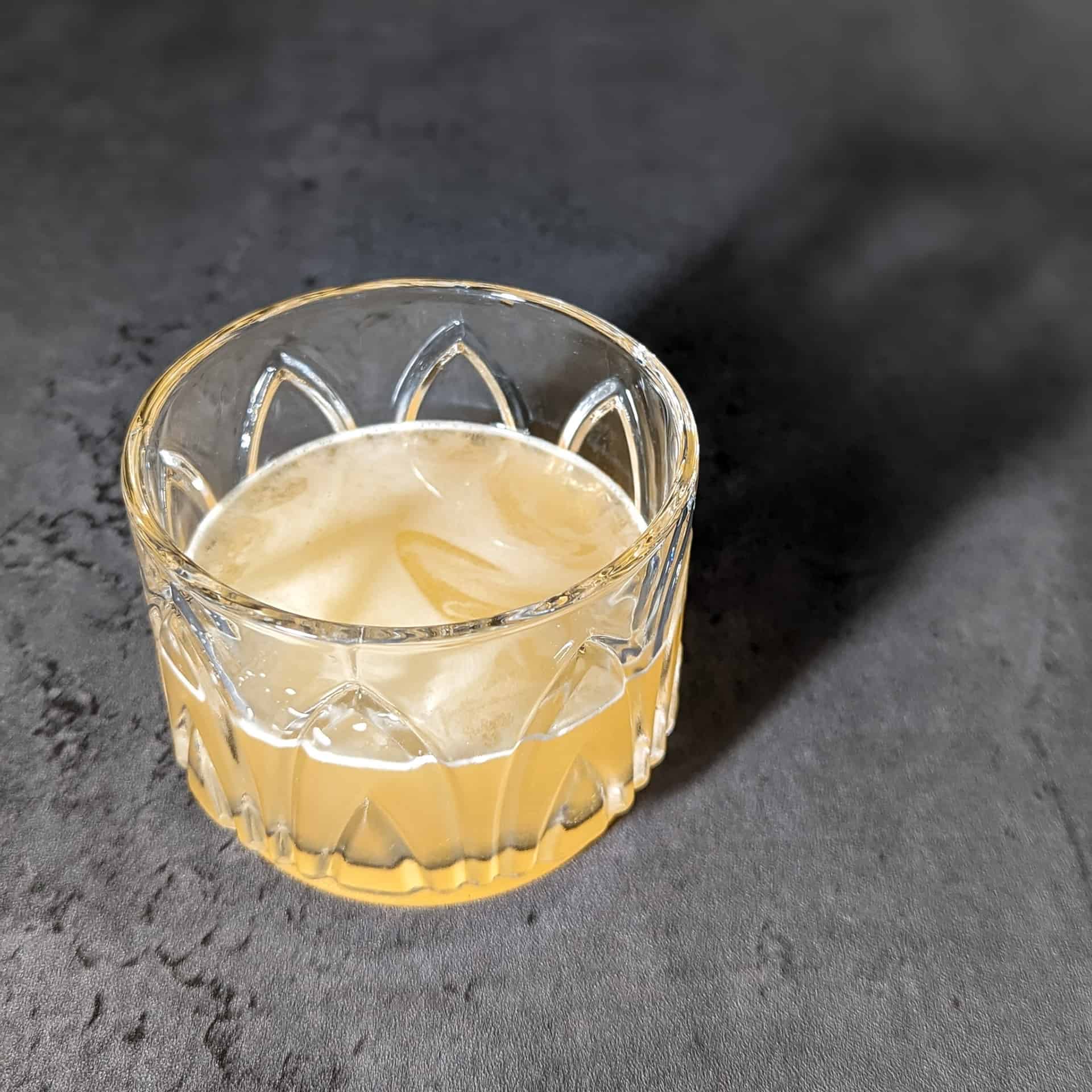 A mezcal sour cocktail made with lemon juice and honey