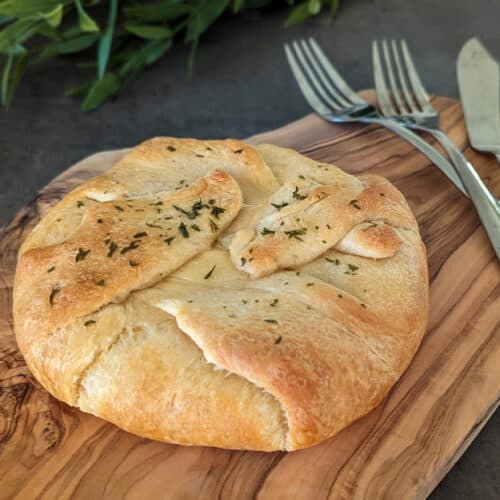 Roasted garlic baked brie en croute made in crescent roll dough