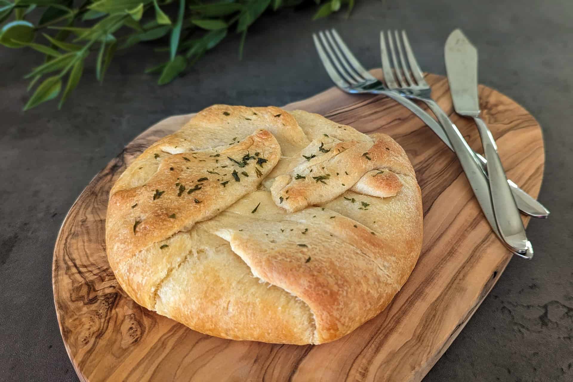 Roasted garlic baked brie en croute made in crescent roll dough