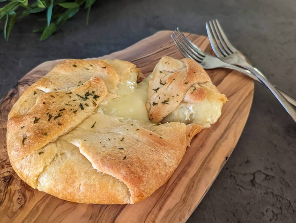 Gooey baked brie cheese inside crescent roll dough, served with two forks