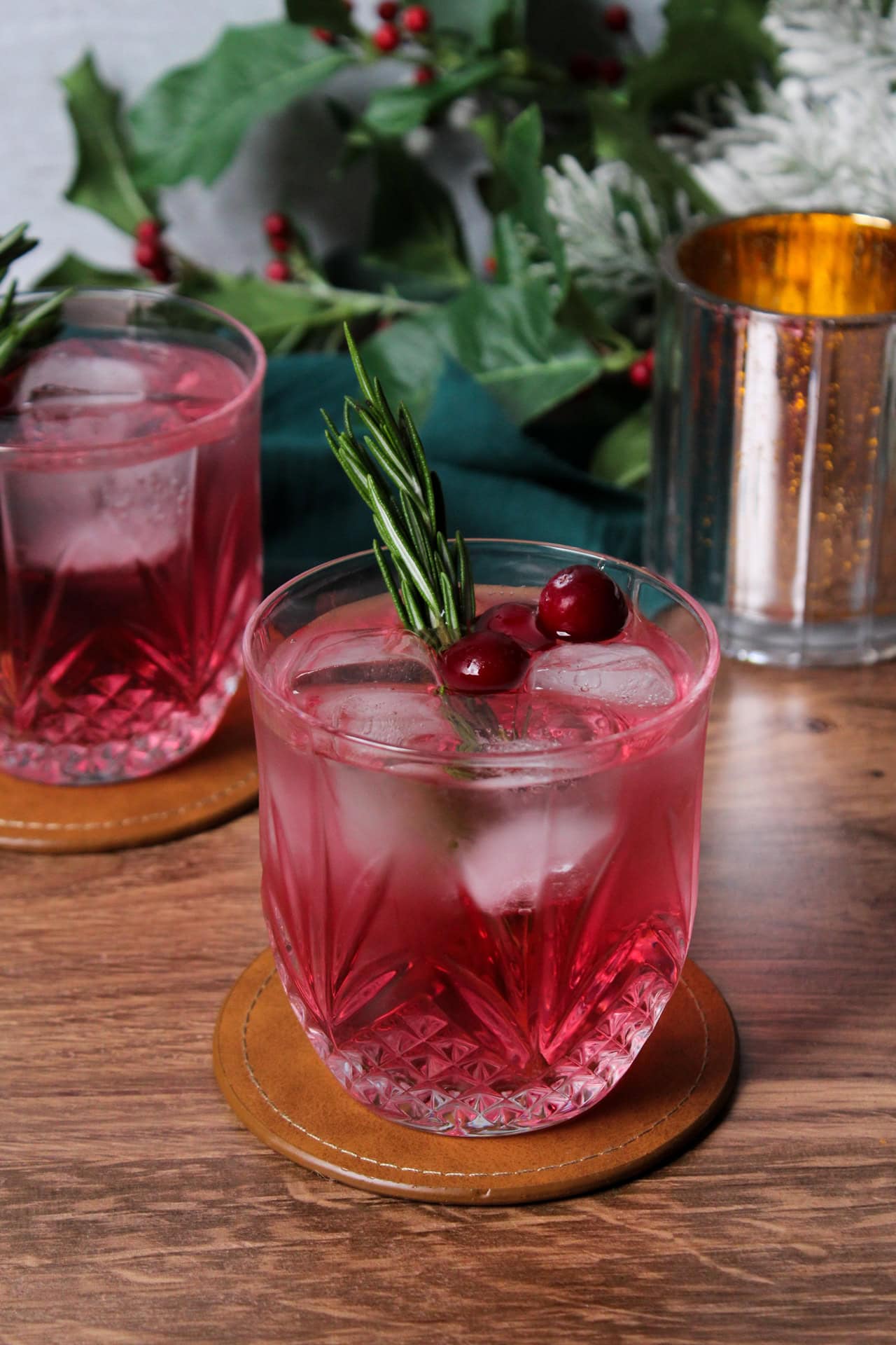 Mistletoe mule cocktail garnished with rosemary and cranberries in a crystal glass.