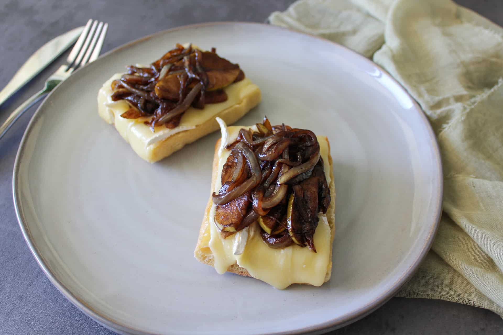 An open faced brie sandwich with balsamic caramelized onions and apple