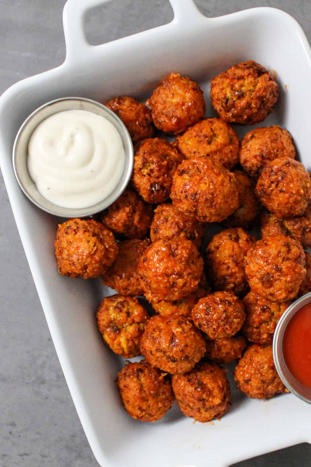 Air fryer buffalo cauliflower bites served with ranch and extra hot sauce
