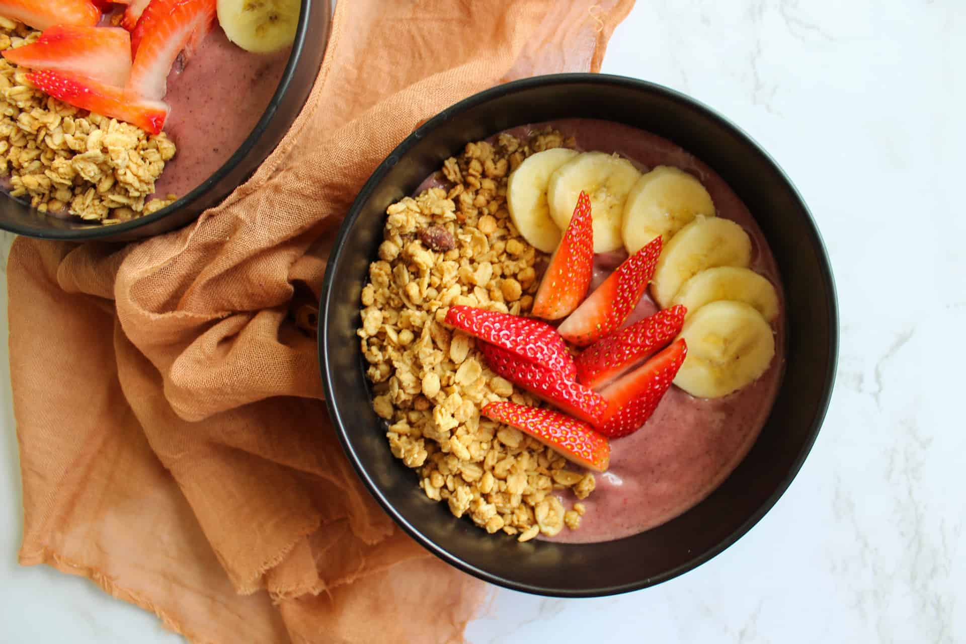 A healthy acai smoothie bowl topped with fresh fruit and granola