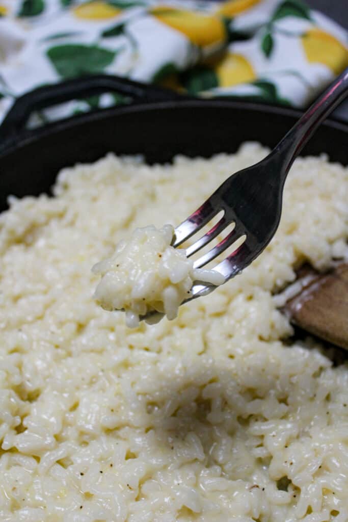 A creamy parmesan risotto being scooped with a fork