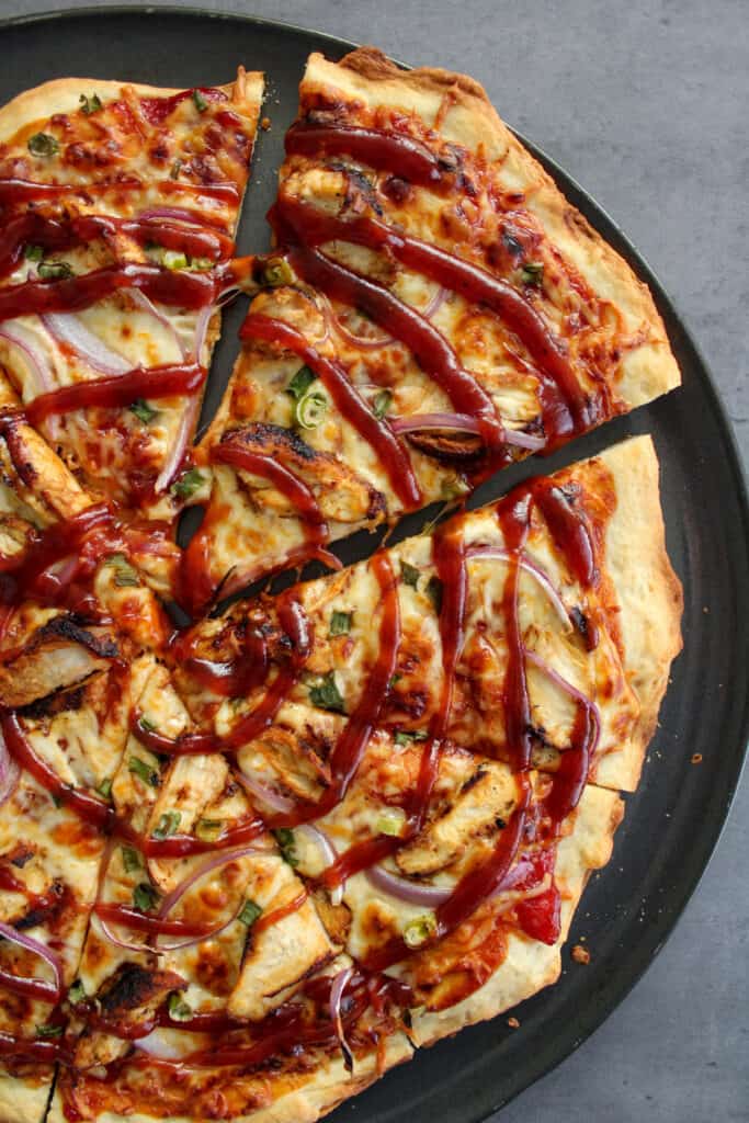A thin crust BBQ chicken pizza made with chicken, barbecue sauce, and red onion