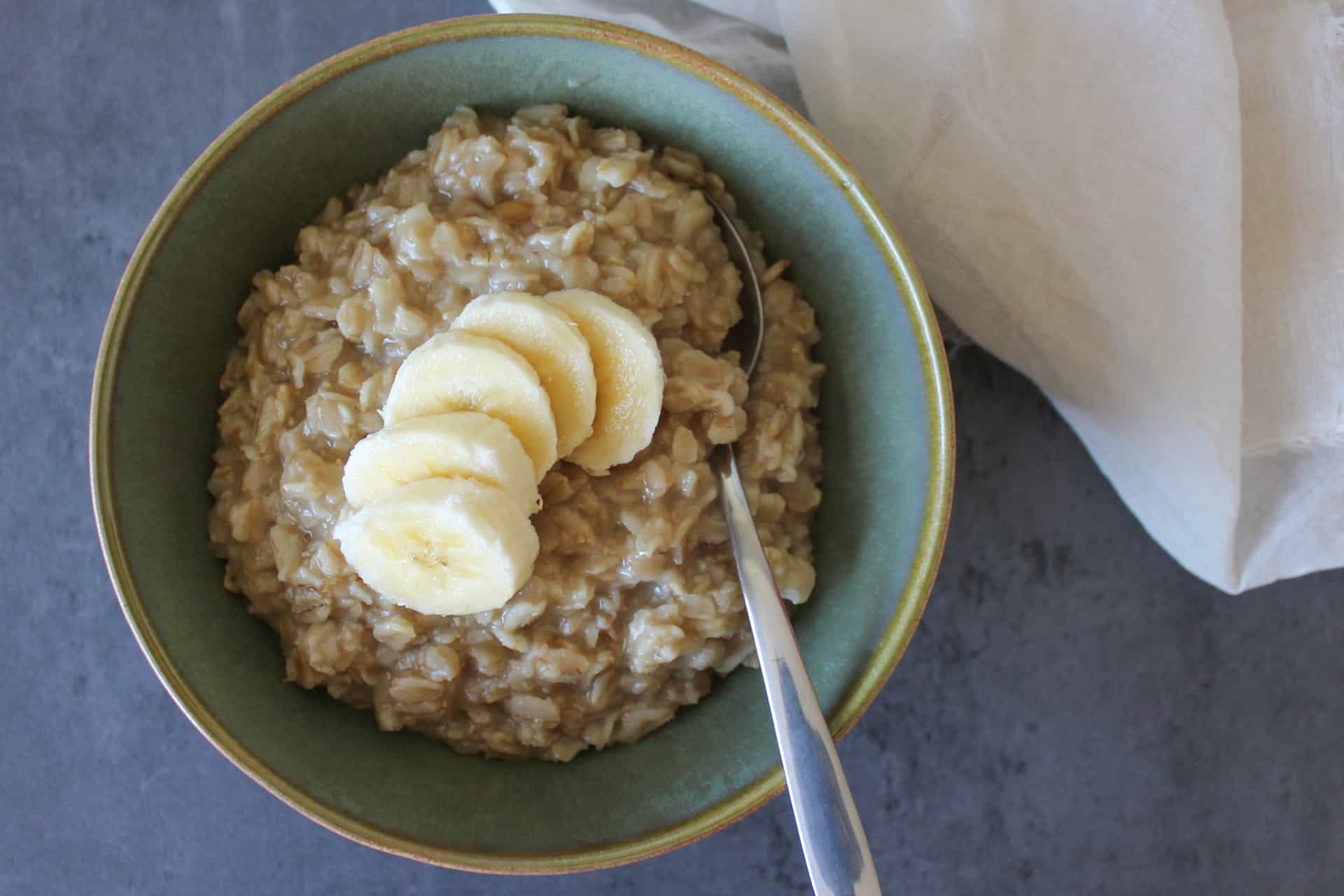 A bowl of maple and brown sugar oatmeal topped with sliced banana