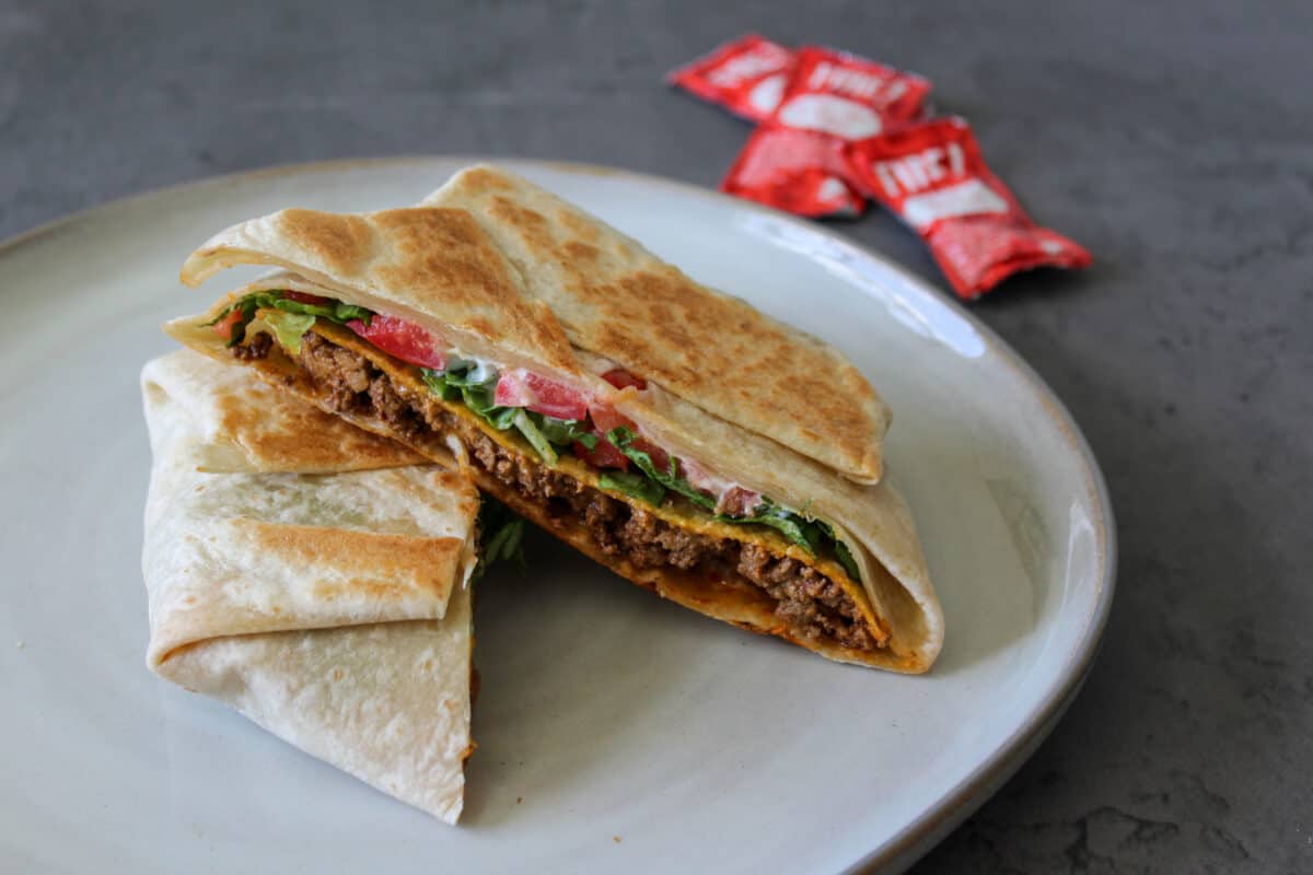 A copycat Taco Bell crunchwrap supreme with Fire sauce