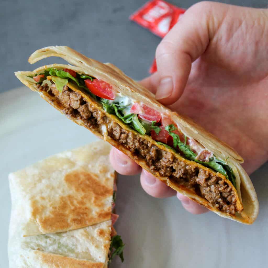 A Taco Bell copycat crunchwrap supreme cut in half to show the layers inside