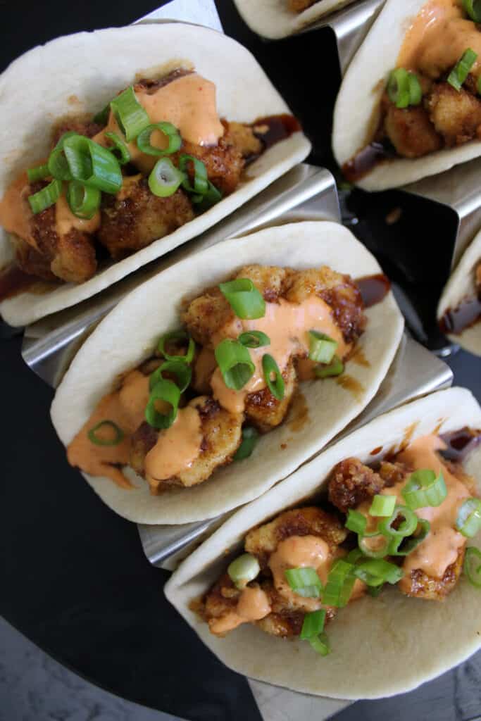 A plate of three Asian inspired fried chicken tacos