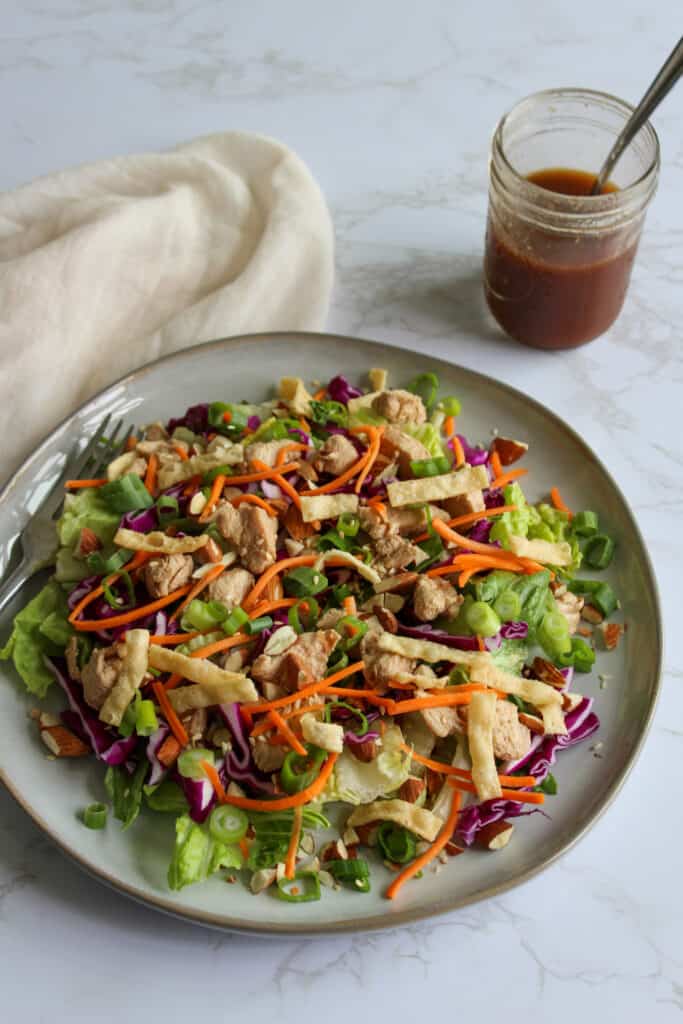 Asian chicken salad with a jar of sesame dressing