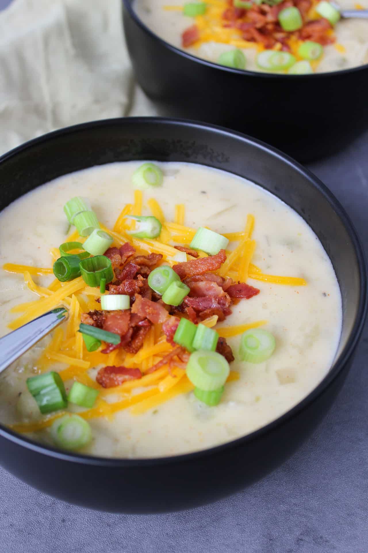 Two bowls of loaded baked potato soup.