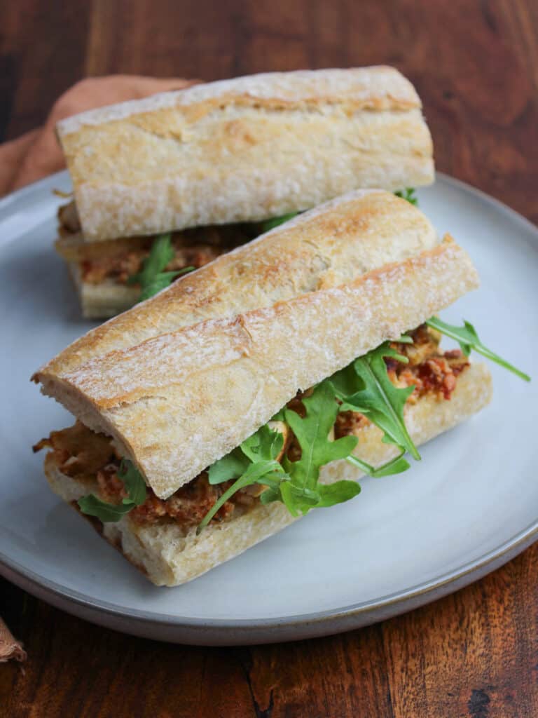 Two chicken and goat cheese sandwiches on a plate.