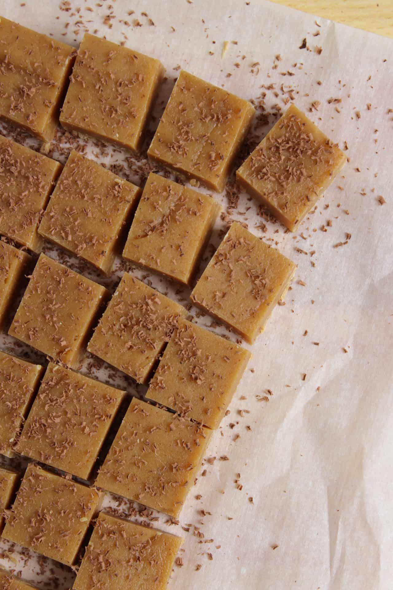 Peanut butter fudge sliced into squares and topped with chocolate shavings.