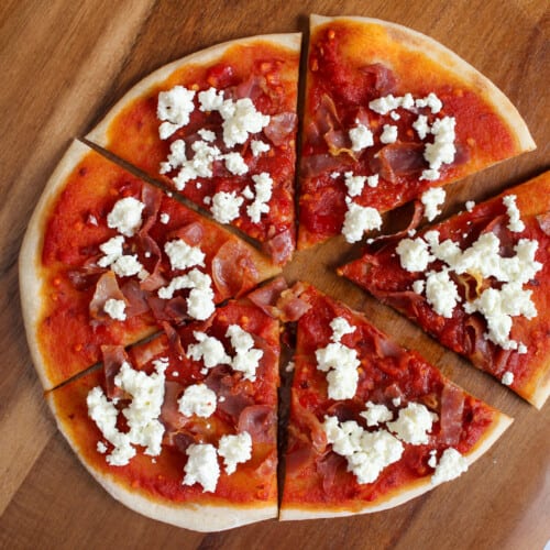 Prosciutto and goat cheese pizza with spicy red sauce.