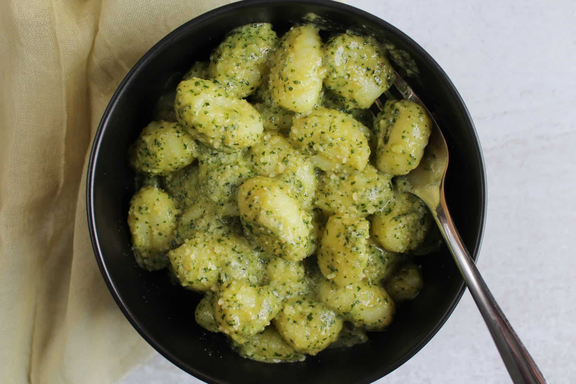 A bowl of creamy pesto gnocchi.